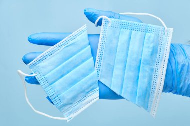 Kesik yüzlü bir maske tutan adamlar koruyucu eldivenler veriyorlar. Coronavirus, SARS-CoV-2 salgını sona erdi. Karantinanın sonu. 