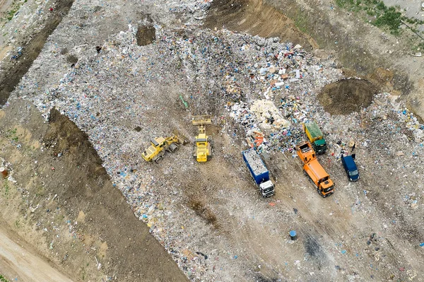 쓰레기 더미가 쓰레기 더미나 매립지에 쓰레기를 하역하는 덤프트럭과 굴착기들 — 스톡 사진