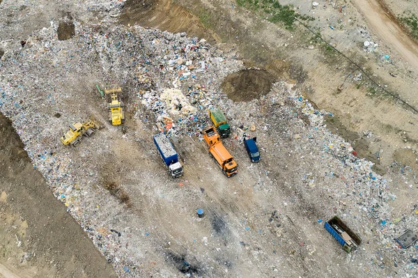 쓰레기 더미가 쓰레기 더미나 매립지에 쌓여 있다. 쓰레기를 하역하는 덤프트럭과 굴착기들. — 스톡 사진