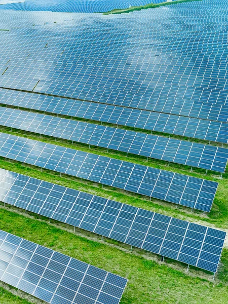 Paneles solares que producen energía verde renovable. Central solar en el campo con césped verde . — Foto de Stock