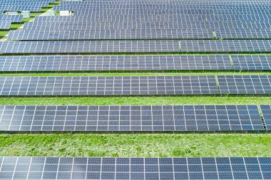 Yeşil çimenli, yatay güneş panelinin hava görüntüsü. Yeşil, çevre dostu, elektrik üretimi için yenilenebilir enerji kaynağı. Büyük güneş enerjisi istasyonu.