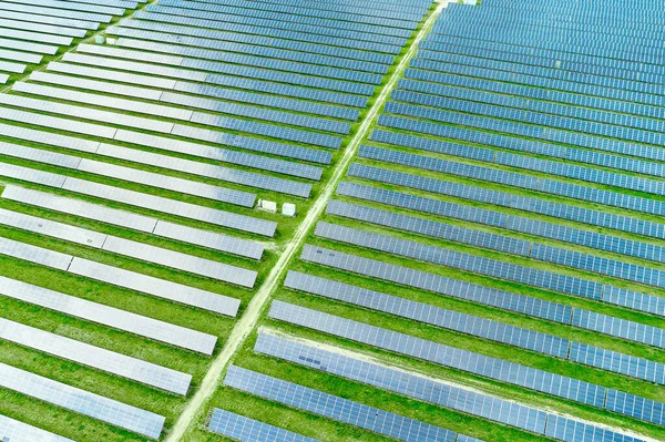 Αεροφωτογραφία του σταθμού ηλιακής ενέργειας στο πράσινο πεδίο για την παραγωγή ενέργειας από τον ήλιο. Φωτοβολταϊκό σύστημα πάνελ για παραγωγή πράσινου, οικολογικού, ενεργειακού. — Φωτογραφία Αρχείου