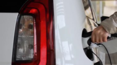 Kadın, halka açık noktadan şarj ettiği için elektrikli araba EV 'sinin fişini çekiyor.. 
