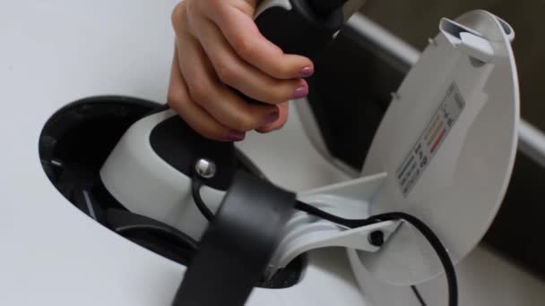 Woman finishes a charging of EV or electric car using power supply cable bottom view. — Stock Video