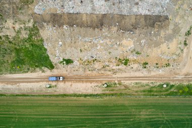 Çöplükte ya da çöplükte çöp yığını var. Çöp kamyonları ve kazıcılar atık boşaltıyorlar. 