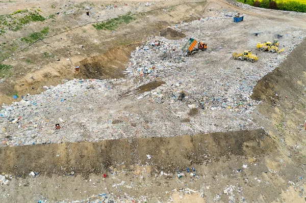 Garbage pile in trash dump or landfill. Dump trucks and excavators unloading waste.