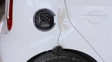 Elektrik kablosunu bir ışıkta kadına bağlamak kapanır. Elektrikli araç EV yükleniyor.