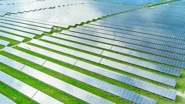 Veduta aerea della centrale solare in campo verde per la generazione di energia dal sole. Impianto pannello fotovoltaico per produzione green, eco friendly, energia. — Foto Stock