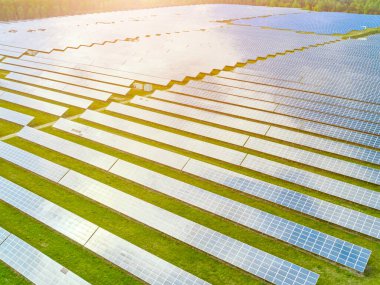 Güneş enerjisi istasyonunun hava görüntüsü. Yenilenebilir enerji üretimi için fotovoltaik paneller alanı. Panellerdeki güneş ışığının yansıması. 