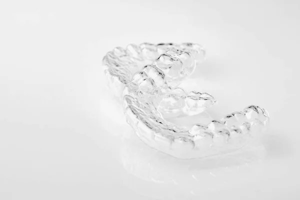Δύο αόρατοι οδοντίατροι στο λευκό φόντο. Ορθοδοντικά προσωρινά αφαιρούμενα στηρίγματα για στερέωση δοντιών μετά την ευθυγράμμιση. Θεραπεία μετά από παρενθέσεις. — Φωτογραφία Αρχείου