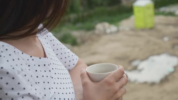 Młoda kobieta z filiżanką herbaty lub kawy nadzoruje budowę nowego domu. Budowanie domów dla klucza. — Wideo stockowe