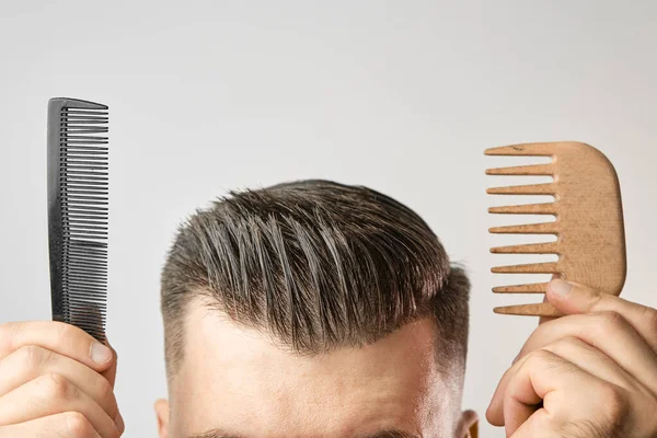 Plastové vs dřevěný hřeben pro styling účes po holičství. — Stock fotografie
