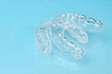 Mavi arkaplanda kopyalanabilir diş düzenleyicileri ve fotokopi alanı. Güzel gülümseme için ortodontik tedavi.