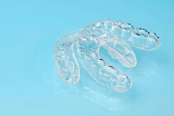 Verwijderbare tanden uitlijnaars op de blauwe achtergrond met kopieerruimte. Orthodontische behandeling voor mooie glimlach. — Stockfoto