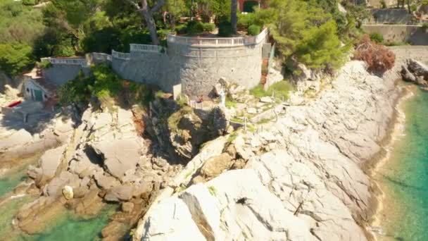 Vuela alrededor de una estatua de Jesús blanco en la colina rocosa en el mar de Liguria. — Vídeo de stock