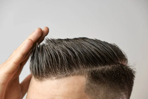 Perfekt styling av hår efter frisör på den grå bakgrunden. Begreppet håravfall. Koncept för kosmetiska produkter för män. — Stockfoto