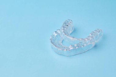 Mavi arkaplandaki görünmez hizalayıcıları fotokopi alanıyla kapat. Dişleri düzeltmek için plastik diş teli diş macunları.