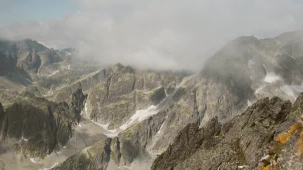 Wysoki kąt wierzchołków skalistych gór pokrytych chmurami nad szczytem. — Wideo stockowe
