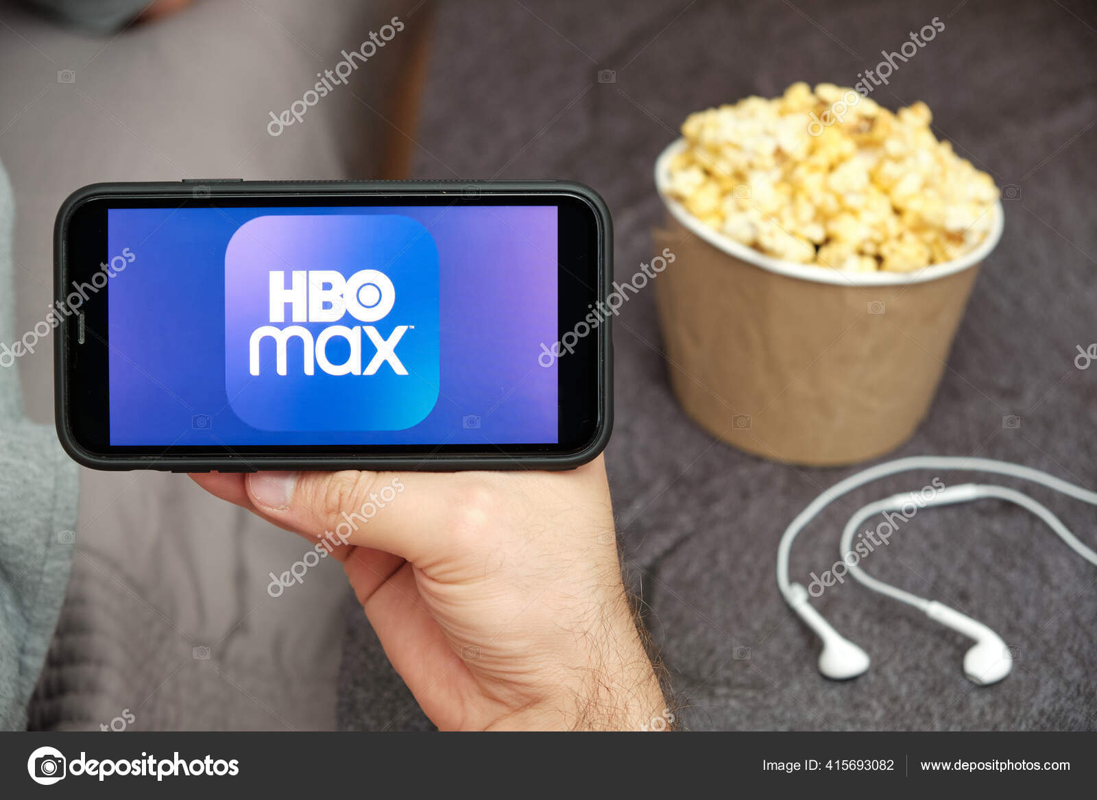 Close up mans hand holding a mobile phone with HBO Max logo with Apple ...