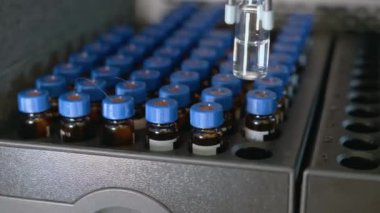 Otomatik örnekleyici bir şişe alır ve yüksek performanslı sıvı kromatografiye bir örnek enjekte eder. 