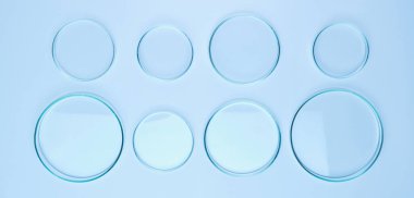 Different size Petri dishes for biochemical analysis on the blue background clipart
