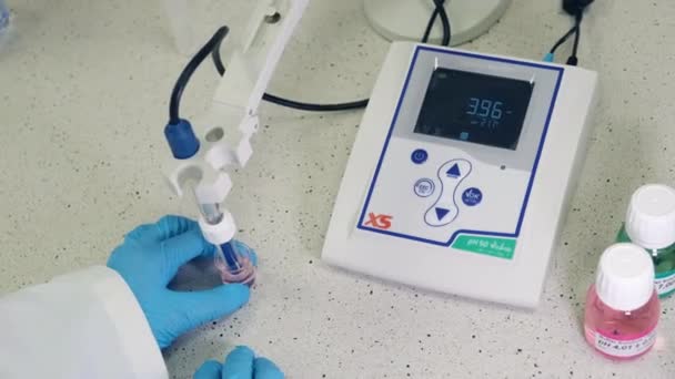 Chemist measures pH using pH meter with glass electrode, October 2020, San Francisco, USA — Vídeos de Stock