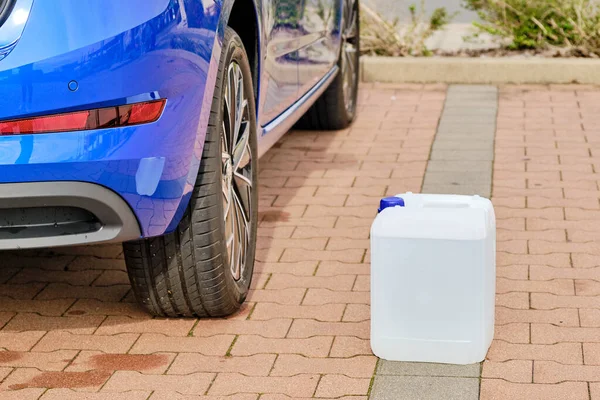 Mavi Skoda otomobilinin direksiyonuna dizel egzoz sıvısı olan beyaz bir teneke kutuyu kapat. Hava kirliliğinin azaltılması için Ad Blue sıvısı, Ekim 2020, Prag, Çek Cumhuriyeti