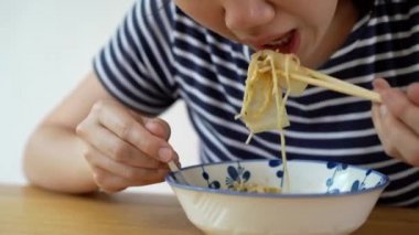 Hazır erişte yiyen bir kadın..