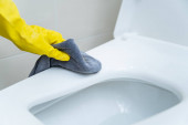 Szobalány tisztító öblítő WC segítségével alkohol és folyadék tisztító oldat. Covid-19 védelmi koncepció, mindig tisztító berendezések a mindennapi életben. Közegészségügy és egészségügy.