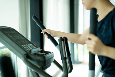 Spor salonunda egzersiz makineleri kullanan Asyalı şişman kadın, fotokopi çekilen Asyalı kadın portresi..