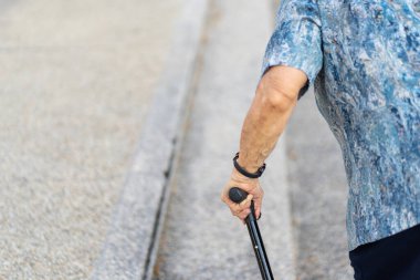 Torun, neredeyse 90 yaşındaki büyükannesine sabah parkta yürüyerek egzersiz yapmasına yardım ediyor. Asyalı bir kadın yaşlı bir kadının yürümesine yardım ediyor. Sağlık, sağlık ve refah..