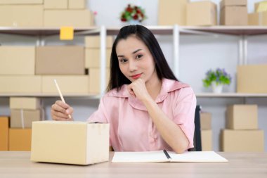 Güzel Asyalı kadın portresi e-ticaret ve online alışveriş konsepti, kadın deftere not yazıyor..