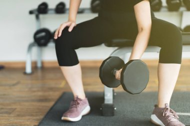 Asyalı sporcu kadın ağırlık egzersizi yapmak için ağır bir dambıl kullanıyor. Modern yaşam tarzı konseptinde spor ve sağlık hizmetleri. Kopyalama alanı olan fotoğraf.
