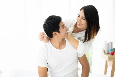 Güzel bir Asyalı çift yatakta uzanıyor ve sohbet ediyorlar. Çift ilişkisi kavramı.