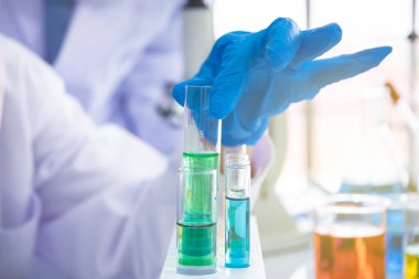 Kimya bilimcisi deney tüpünü yakına alıyor..