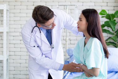 Asyalı genç bir kadının hastanede dinlenirken karın ağrısı vardı. Kafkasyalı uzman doktor ciddi bir kadın hastayla tanışıp hastalığıyla ilgili konuşmaya geldi. Sağlık hizmetleri kavramı.