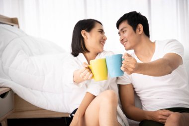 Asyalı genç bir çift, sabahları kahve içip eğleniyor. Boş zaman, çift, ilişki ve sevgililer günü konsepti. Kopyalama alanı olan fotoğraf