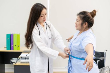 Doktor, şişman kadın hastaya aşırı kilo problemi hakkında danışmanlık yapıyor. Günlük yaşam konseptinde sağlık ve sağlıklı yaşam tarzı.