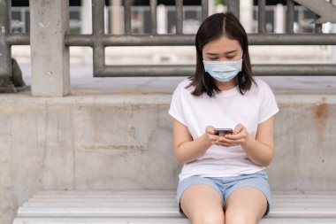 Asyalı turist taksi şoförüyle randevu almak için akıllı telefondan taksi başvurusu yapıyor. Akıllı telefon kullanarak taksi şoförü arayan bir kadın. Copyspace ile modern kentsel ulaşım kavramı.