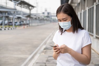 Asyalı turist taksi şoförüyle randevu almak için akıllı telefondan taksi başvurusu yapıyor. Akıllı telefon kullanarak taksi şoförü arayan bir kadın. Copyspace ile modern kentsel ulaşım kavramı.