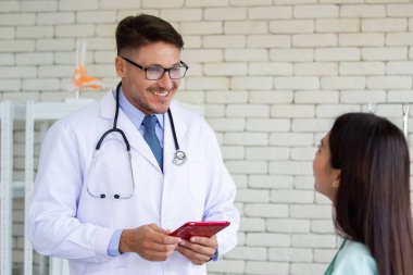 Asyalı kadın, hastanede profesyonel doktorla görüşürken grip virüsü kapmış. Doktor, sağlık ve hastalıktan kaçınmayı açıklıyor. Tıbbi danışmanlık hizmeti.