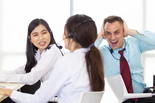 Harmful noisy environment in the workplace issue. A man screaming to his colleague who enjoy talking louder in the office. Stress and problem in workplace with co-worker and other employees concept.