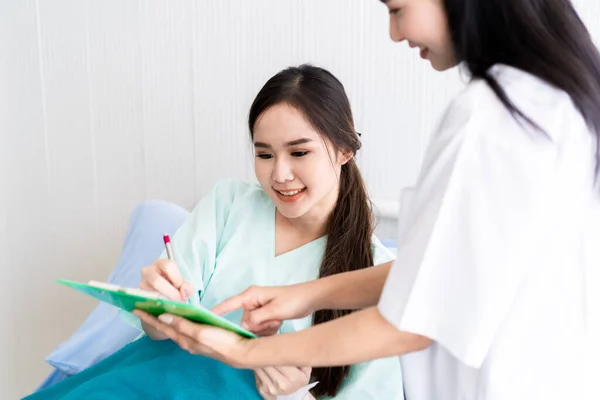 Азиатская Молодая Женщина Подписывает Больничный Бланк Здравоохранение Страхование Жизни — стоковое фото