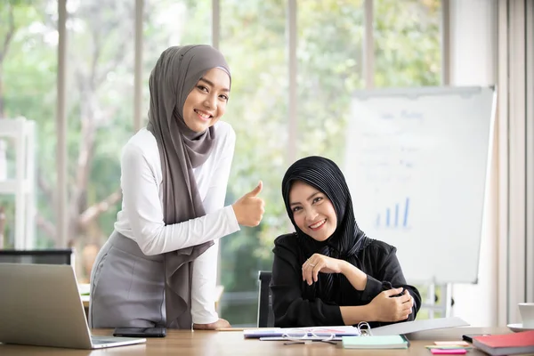 アジアの若いイスラム教徒のビジネス女性がオフィスで一緒に働いています ムスリムビジネス女性のキャリアパスに成功しました 現代人におけるプロの同僚とチームワークの概念 — ストック写真