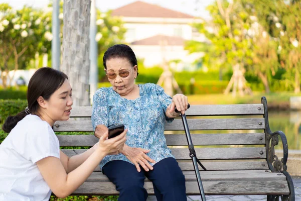 Nipote Mostrando Alla Nonna Contenuto Smartphone Durante Sono Seduti Parco — Foto Stock