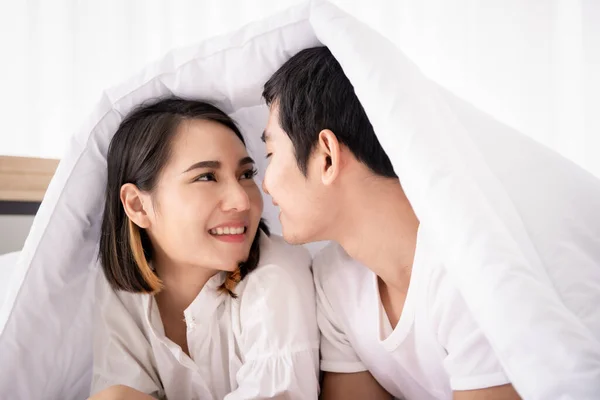 美しいアジアのカップルが横たわってベッドの上で一緒に話しています 夫婦関係の概念 — ストック写真