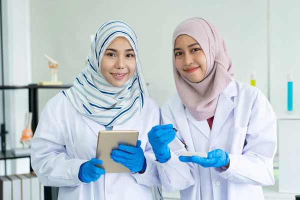アジアの若いイスラム教徒の科学者は病院の実験室で化学実験をテストします 研究室での専門医薬品化学者の調査と実験 — ストック写真
