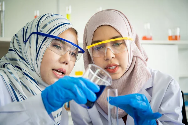 Asian Muslim scientist women working in laboratory close up.