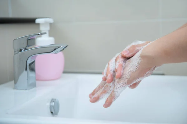 Woman washing her hands by using liquid hand washer soap for protecting from coronavirus 2019, COVID-19 virus inflection risk. Washing a hands can increase personal hygiene and protect from virus.