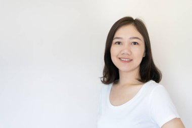 25-30 yaşlarında Asyalı güzel bir kadının portresi. Beyaz arka planda ve fotokopi alanı var. Özgüvenli Asyalı genç yetişkin portresi düşünceli bir duygu içinde..